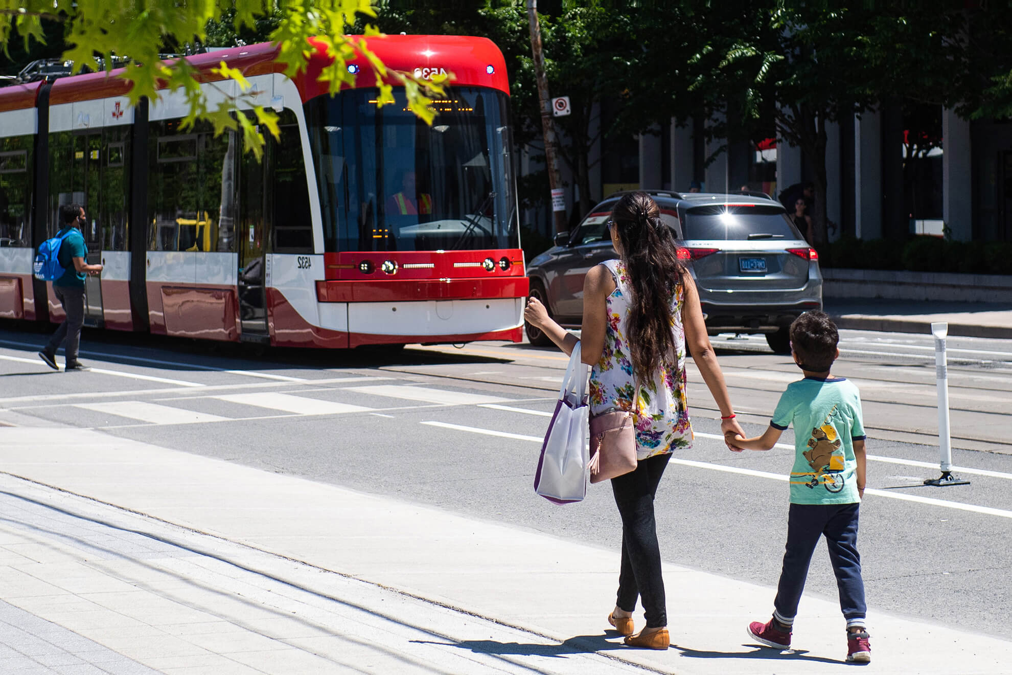 Mother and son walking toward a streetcar